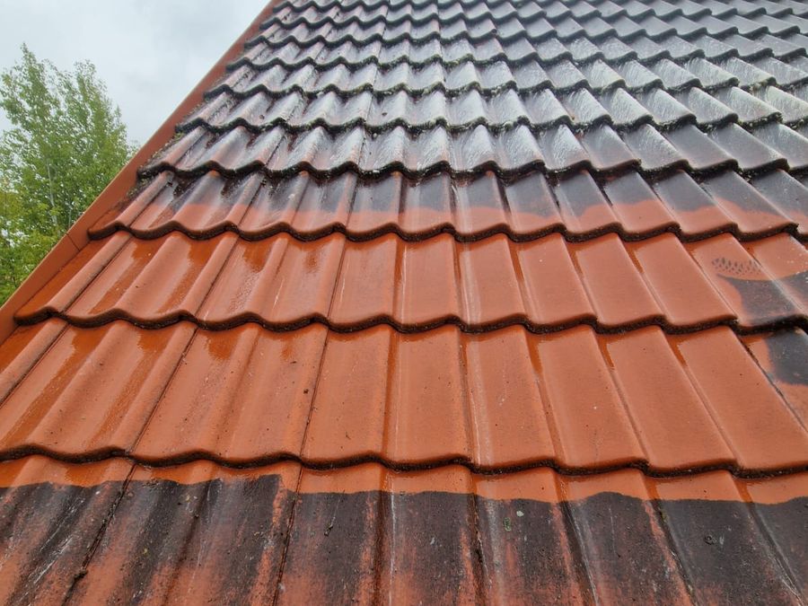 Dach z dachówki ceramicznej w trakcie mycia, widoczna granica czystej połaci
