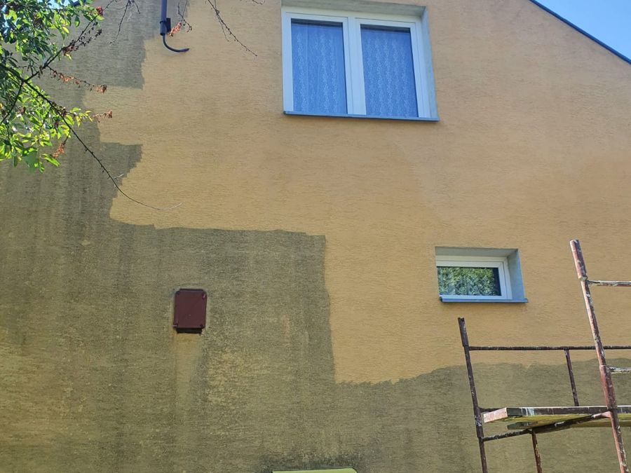 Elewacja domu jednorodzinnego w trakcie mycia, widoczna różnica kolorów