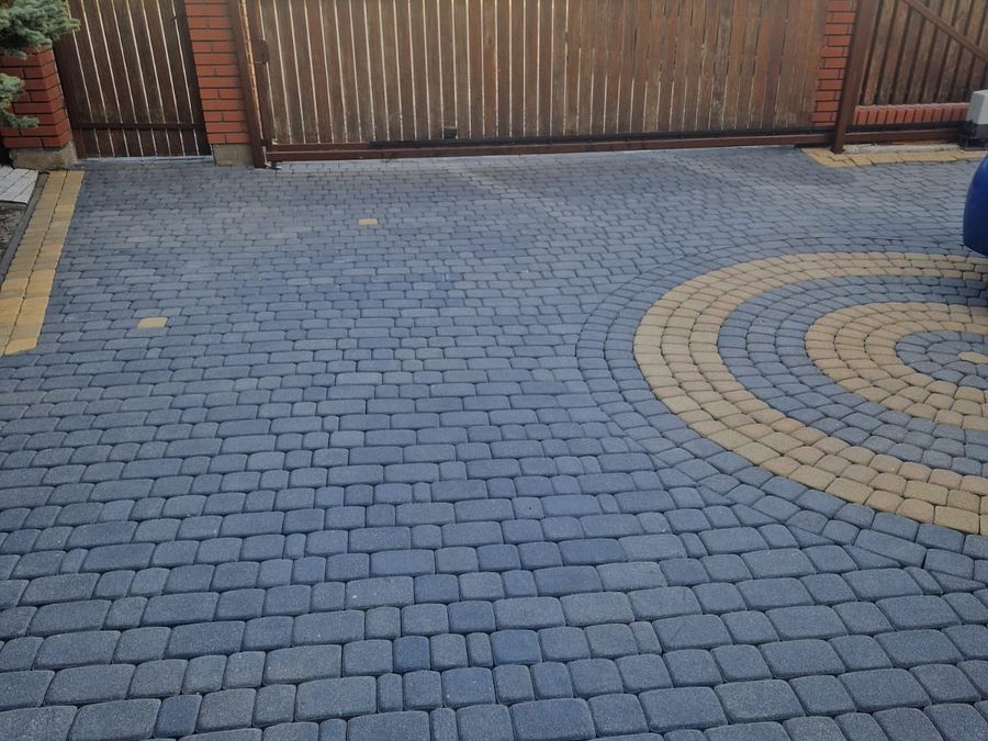 Podjazd z ciemnej kostki brukowej z rozetą po umyciu ciśnieniowym