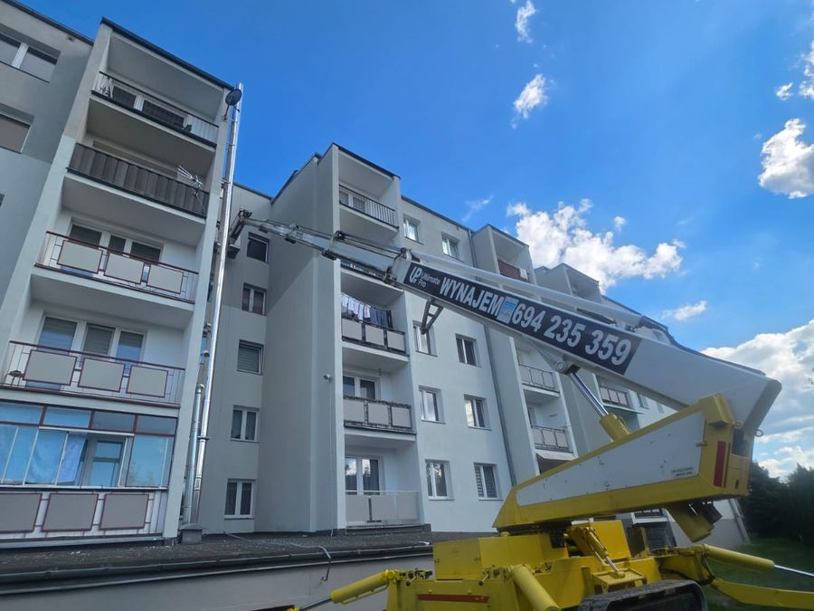 Podnośnik koszowy UltimatePro rozstawiony przy budynku wielorodzinnym